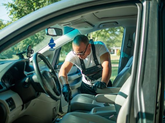 Detailer deep-cleaning a vehicle interior seat by seat
