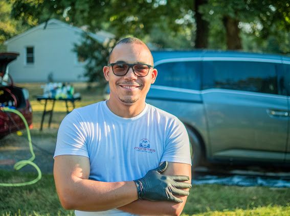 Royman Carreras, founder of Monster Car Detailing, smiling in front of a freshly detailed vehicle
