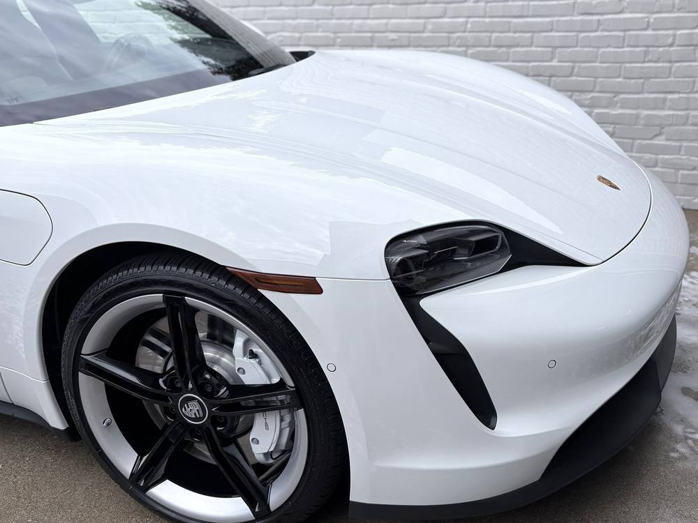 White Porsche Taycan with glossy finished paint after detailing